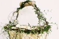 a wire basket decorated with some greenery is a cool idea with a rustic feel