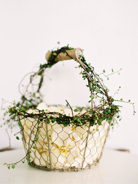 a wire basket decorated with some greenery is a cool idea with a rustic feel