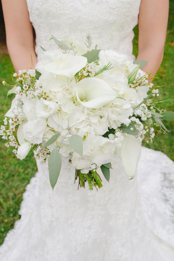 an all-white wedding bouquet of callas, roses, tulips, waxflower and some greenery is gorgeous for spring or summer