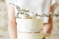 an ethereal white semi naked wedding cake topped with macarons and flowers is amazing for a spring wedding