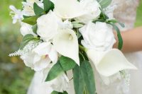 an exquisite cascading wedding bouquet of calla lilies, roses and some white fillers plus greenery is amazing for spring