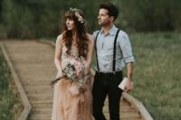 an informal meets boho groom’s look with a light blue shirt, black jeans and suspenders and black shoes