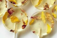 beautiful clear yellow round lollipops with flower petals are a great idea for a summer or fall wedding, and dried blooms are super popular
