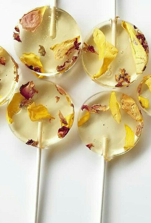 beautiful clear yellow round lollipops with flower petals are a great idea for a summer or fall wedding, and dried blooms are super popular