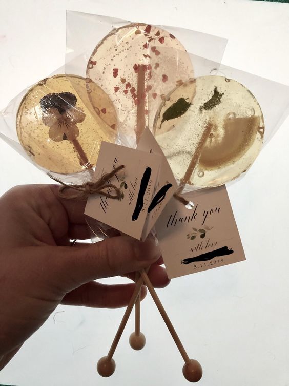 clear lollipops with dried blooms and leaves, with hearts and tags are amazing for a wedding in any season and with any theme