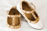 shiny white flats with tan straps and studs are a very trendy and bold option to rock