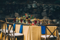 the Beauty and the Beast inspired tablescape done in gold, bold blue and deep red plus gold rim glasses and bright florals