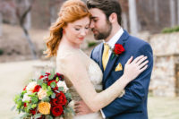 the groom wearing a blue suit with a yellow tie and handkerchief, a red rose boutonniere to match the Beauty and the Beast groom’s look