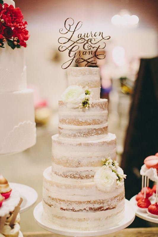 an elegant naked wedding cake with white blooms and a gold calligraphy topper will fit even a formal wedding