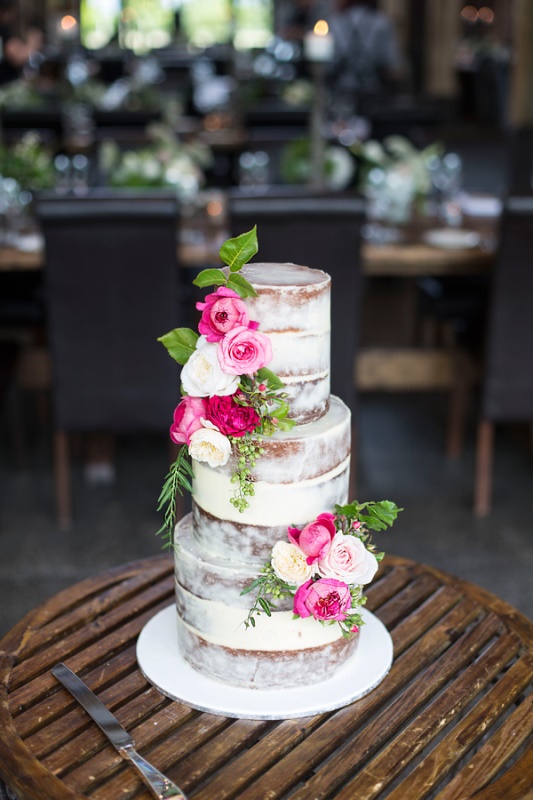 a naked wedding cake with pink and white blooms and lots of greenery is a chic idea for a bright summer wedding