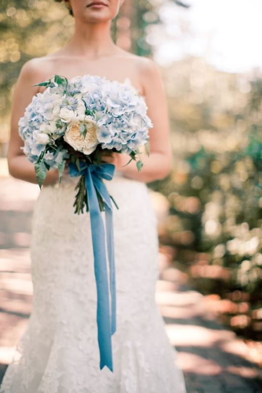 a romantic wedding bouquet of blue hydrangeas and some neutral peony roses accented with long blue ribbons is a very cool and stylish idea