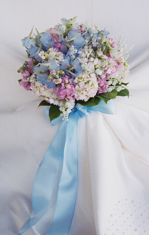 a pretty wedding bouquet featuring pink, serenity blue and white blooms and long blue ribbons is a very cool and bold idea for your bright wedding