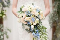 a chic cascading wedding bouquet of blush blooms, serenity blue and white ones plus some greenery going down is amazing