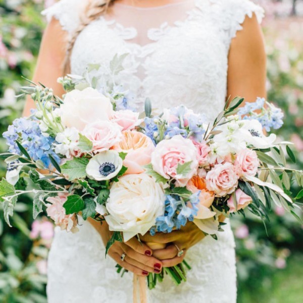a super lush and dimensional wedding bouquet made of blue blooms, light pink roses, white peony roses and anemons plus lots of greenery