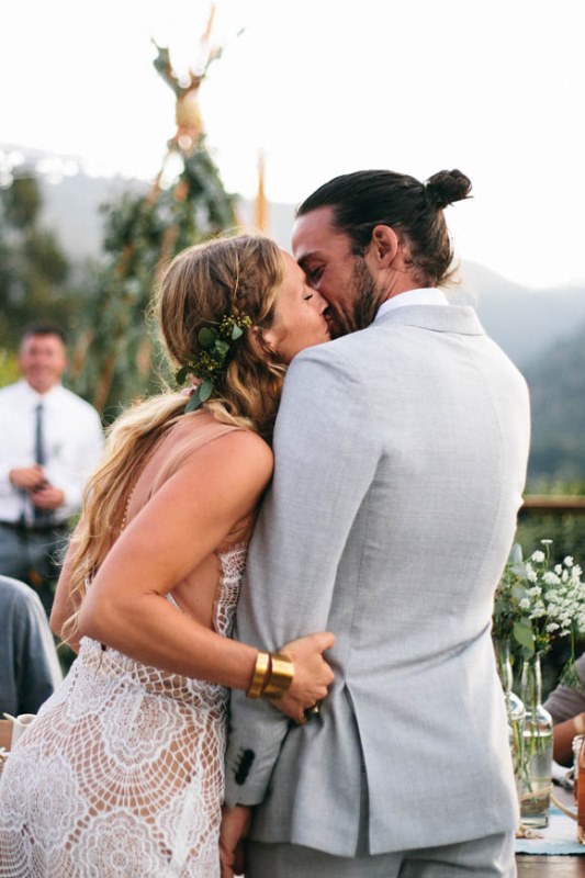 a light grey suit with a white shirt and a man bun for a relaxed and stylish summer boho groom's look