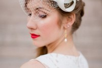 a mini birdcage veil with an oversized white bow on top is a pretty and modern idea for a refined bride