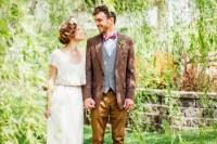 an elegant and chic groom’s look with mustard pants, a grey waistcoat, a muted red blazer, a bright red bow tie
