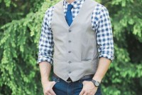 a relaxed barn groom’s look with jeans, a checked button down, a grey waistcoat and a bright blue tie