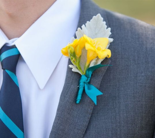 a bold wedding boutonniere of yellow freesias and pale leaves plus blue ribbon is a lovely idea for a bright wedding