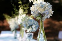 a delicate wedding centerpiece of a bottle with blue and white hydrangeas and white freesias is amazing for a neutral or pastel wedding