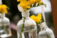 bottles with yellow freesias are amazing and simple wedding decorations with a rustic feel