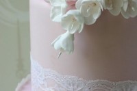 a blush wedding cake decorated with blush roses and white freesias and white lace is a lovely idea for a spring or summer wedding