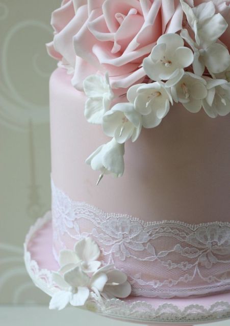 a blush wedding cake decorated with blush roses and white freesias and white lace is a lovely idea for a spring or summer wedding