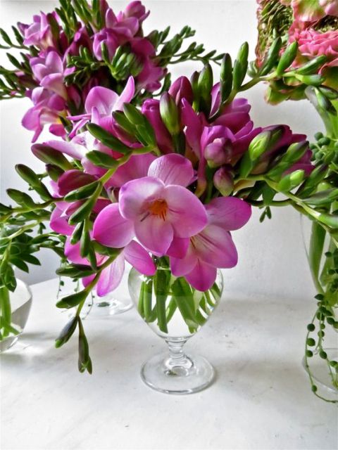 a super lush wedding centerpiece of hot pink freesias and greenery is a perfect solution for a bright wedding