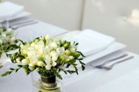 a wedding centerpiece of white freesias and greenery is a lovely idea for a neutral wedding and composing it is very easy