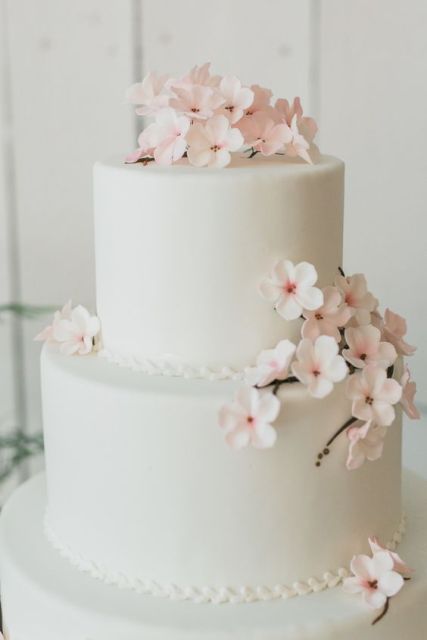 a white wedding cake decorated with cherry blossom is a chic and lovely idea for a spring wedding, it gives a lovely and delicate spring look to the wedding reception
