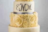 a yellow wedding cake with sleek and floral tiers, with grey ribbons and silver monograms is a very stylish and chic idea