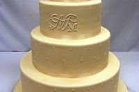 a tan wedding cake with tan ribbons and polka dots plus monograms is a classic idea to go for