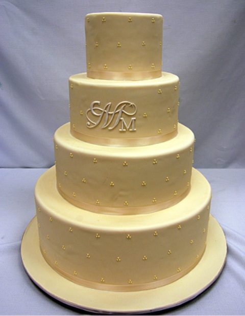 a tan wedding cake with tan ribbons and polka dots plus monograms is a classic idea to go for