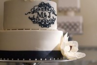 a black and white wedding cake with patterns and monograms plus white sugar blooms is a very cool and elegant idea to rock
