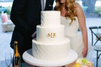 a white textural wedding cake with gold monograms is a classic idea for many weddings