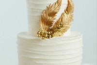 a white textural wedding cake decorated with gold feathers and beds is a lovely and cool idea
