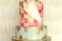 a light blue wedding cake with gold leaf and with a bright chevron tier plus gilded sugar feathers looks bright and cool