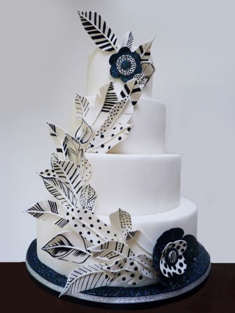 a navy and white wedding cake decorated with sugar 3D painted navy and white feathers and blooms