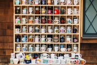a cool coffee mug station with various mugs as wedding favors ad marquee lights is great for a coffee-loving wedding