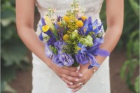 a bright wedding bouquet of blue irises, billy balls and some more purple bloos is a catchy idea for a spring or summer bride