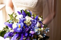 a bold wedding bouquet of blue irises, neutral blooms and greenery is a colorful solution for a modern wedding