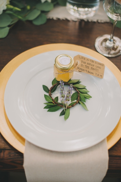 place honey jars with personalized tags and greenery right on the plate to give them as favors at your wedding