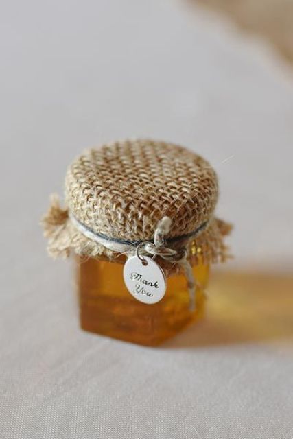 a jar with honey as a wedding favor with a tag is a lovely idea for a wedding, especially for a rustic one