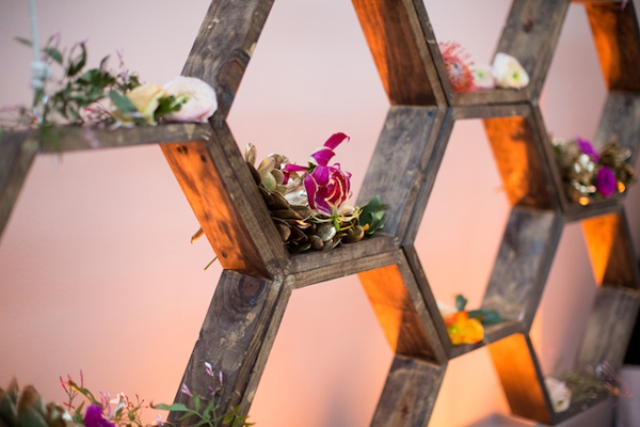 a honeycomb wooden shelf decorated with blooms and greenery is a lovely decoration for a rustic wedding
