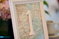 a pastel floral centerpiece and a map table number for a cool travel-themed wedding