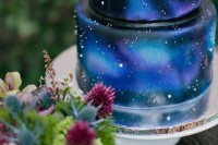 a bold galaxy-inspired wedding cake done in navy, bold blue, midnight blue and purple and accented with sparkles