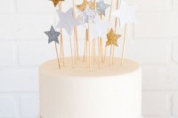 a white wedding cake topped with metallic stars of various sizes is a fun and cool idea for an astronomy wedding