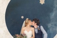 a photo booth with a large half moon and stars, metallic ones to stand out in a dark backdrop