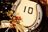 a wedding table number of a horseshoe, a number, some berries and a silk bow is great for a rustic wedding