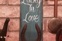 a wedding sign of a wooden plank and a horseshoe is a simple and cool rustic decor idea for a wedding